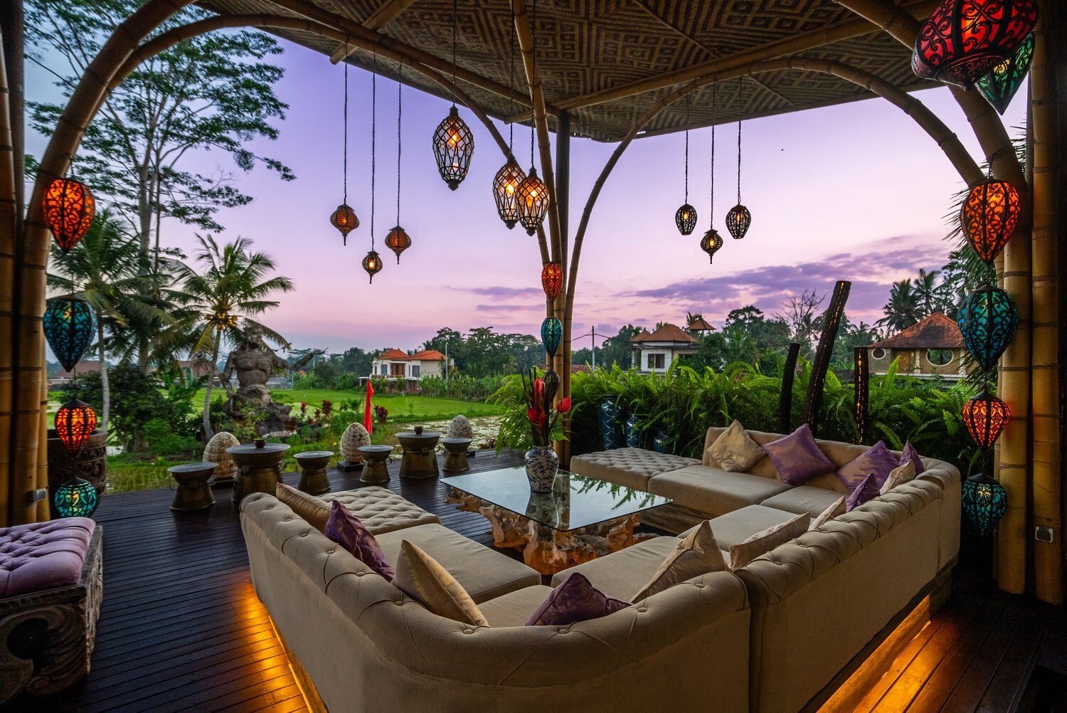 Loungers beside a pool in tropical garden planting at dusk.